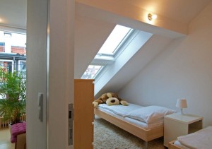 kleiner Schlafplatz unter der Dachschräge mit Fenster