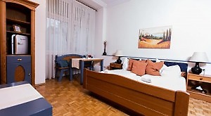 braunes Holzdoppelbett im Pensionszimmer in Wien