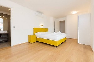 Schlafzimmer mit gelben Doppelbett in Ferienunterkunft Wien