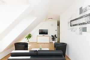 Wohnzimmer mit schwarze Ledermöbel und TV in fewo Wien