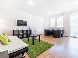 Wohnzimmer mit TV, Sofa, Essplatz in Wien Unterkunft 