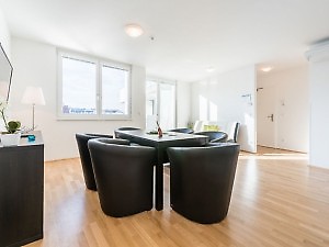 Wohnzimmer mit Essplatz und schwarzen Stühlen in Fewo Wien 