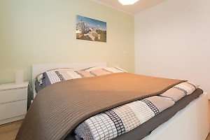 elegantes Doppelbett mit brauner Tagesdecke in Ferienwohnung