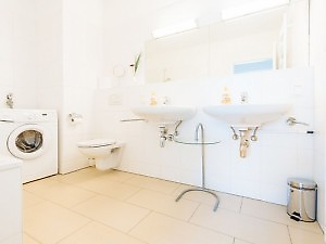 Bad mit Doppelwaschbecken und Waschmaschine in Wien