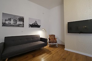 Sofa und Flatscreen-TV an der Wand in Wien Unterkunft 