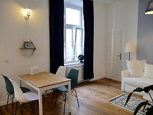 blaue Vorhänge und Essplatz mit 4 Stühle Wien Ferienwohnung