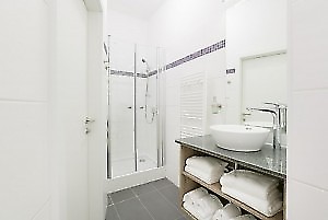 Badzimmer mit Waschtisch, Handtücher und Dusche in Fewo Wien