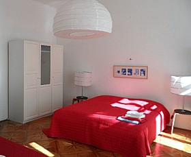helles Schlafzimmer mit Doppelbett und großartiger Lampe
